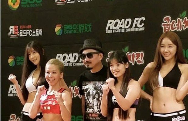 That's Lee on the left of the creepy guy with the hat, getting towered over by the ROAD FC ring card girls.