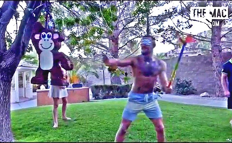 A blindfolded Conor McGregor lining up his shot on the piñata. 
